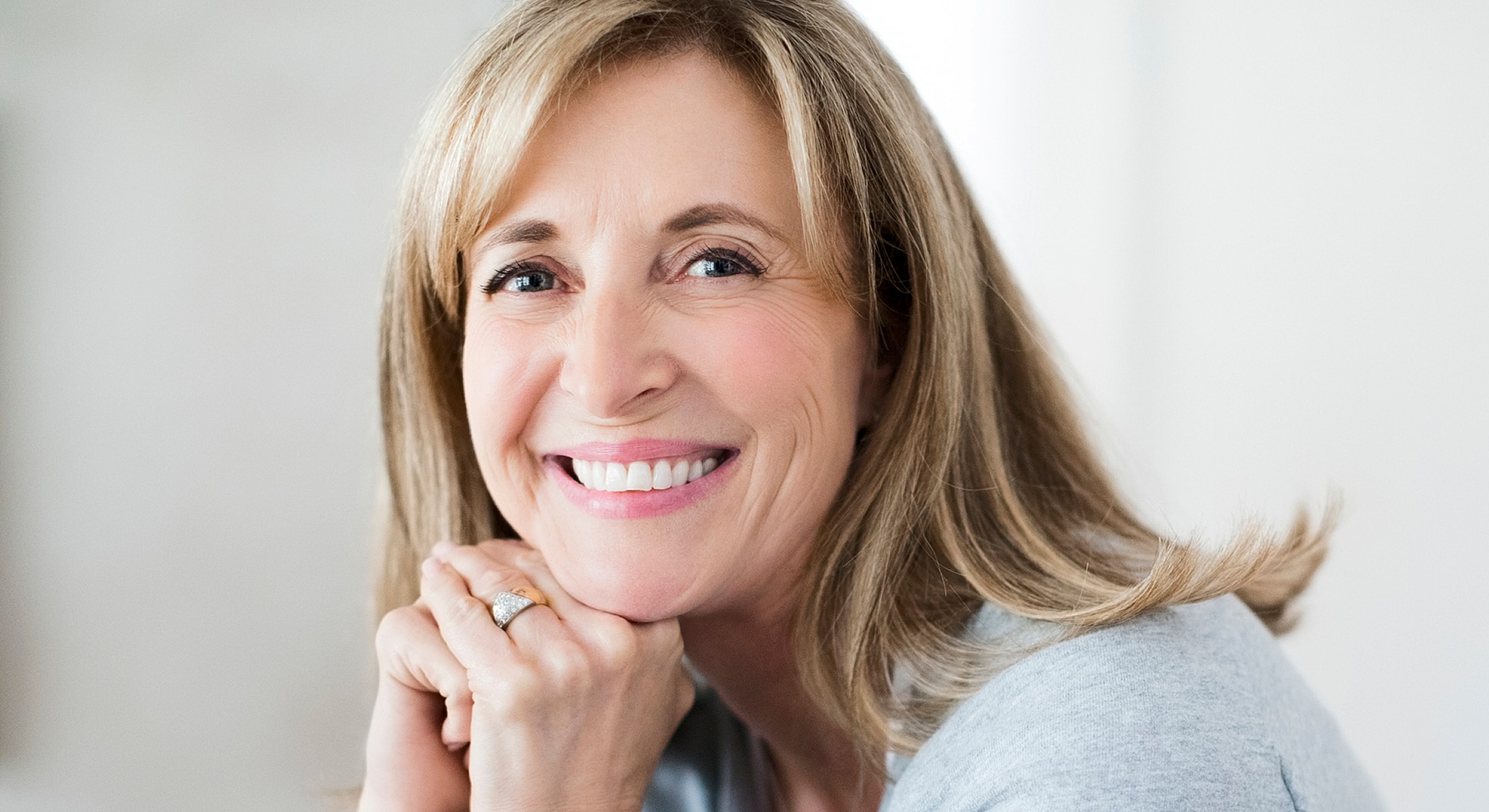 Smiling woman with long hair, relaxed expression.